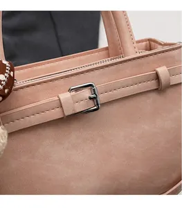 Dettaglio borsa in camoscio rosa con fibbia metallica e accessorio foulard a pois