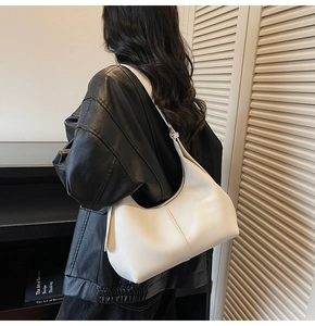 Detail of white lychee leather hobo bag with seamless stitching on a shoulder strap