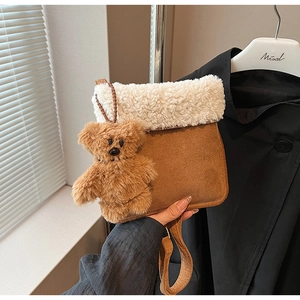 Detalle de bolso bandolera de ante sintético con ribete de borreguito y oso de peluche
