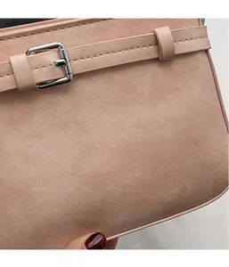 Dettaglio borsa a tracolla in camoscio rosa con fibbia in metallo argento e cuciture precise
