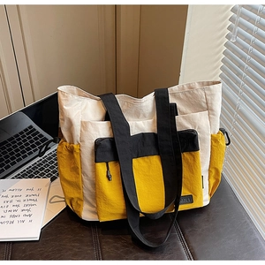 Detail of contrasting yellow and beige tote bag with a matching small pouch for travel