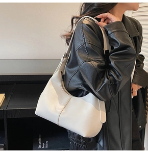 Close-up of a white lychee grain leather crescent bag showing the texture and zipper detail