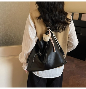 Détail du sac cabas en similicuir noir avec fermetures éclair et pendentif ours