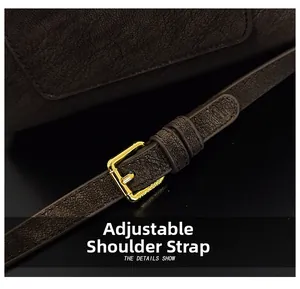 Détail de la bandoulière réglable avec boucle dorée sur sac en cuir marron foncé