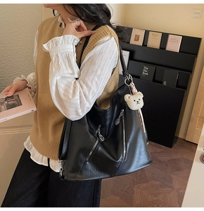 Détail du grand sac cabas en cuir noir avec fermeture éclair et pendentif ours