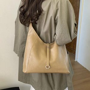 Detail view of large camel leather tote bag with silver ring and decorative strap