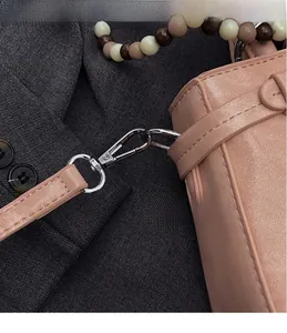 Dettaglio del gancio in metallo argento e della tracolla in pelle color pesca borsa