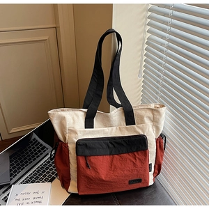Detailed view of canvas tote bag with contrast panels and functional side drawstring pocket