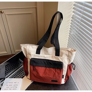 Detail of color-block tote bag showing nylon texture and functional pockets