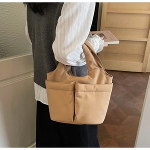 Macro detail of camel nylon tote bag showing double large pockets and wide handles