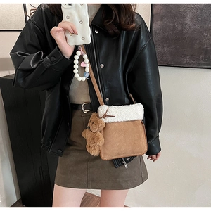 Bolso cubo de ante marrón con ribete de felpa blanca y colgante de oso peluche