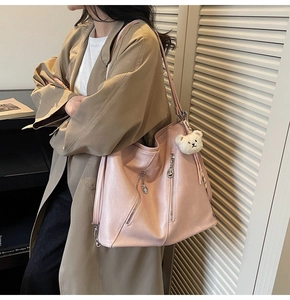 Détail du sac cabas rose en similicuir avec charme d'ours en peluche et fermetures éclair