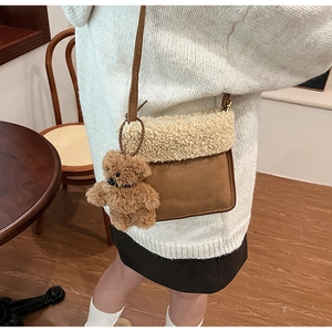 Bolso bandolera de ante marrón con ribete de piel sintética blanca y colgante de oso