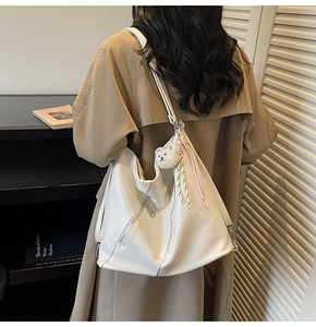 Détail du grand sac cabas blanc avec texture en cuir souple et breloque ours