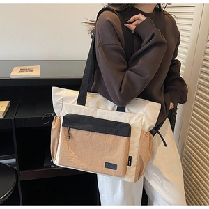 Detail view of the multi-pocket patchwork tote bag featuring khaki and black accents