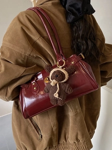 Vintage burgundy glossy leather pillow bag with a cute brown knit bear charm accessory