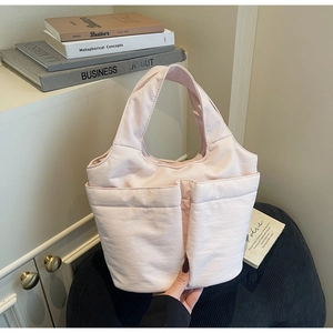 Detail of light pink canvas tote bag with front pockets on an elegant home decor setting