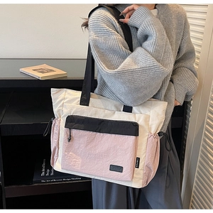 Detail of multi-color tote bag featuring front flap pocket and drawstring side design