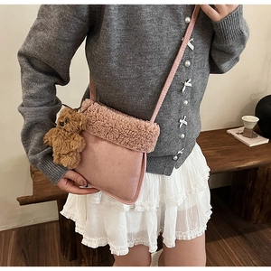 Detalle del bolso bandolera de felpa rosa con ribete de sherpa y colgante de osito