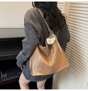 Détail d'un grand sac cabas marron avec fermeture éclair et porte-clés ours blanc