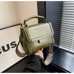 Detail der olivgrünen Lederhandtasche mit einem modischen breiten gewebten Schultergurt