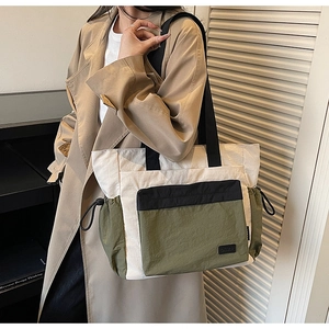 Detail of high-capacity tote bag with contrast panels and functional drawstring side