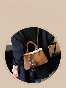 Detail of vintage brown bucket bag featuring plush trim and ring handle with bear charm