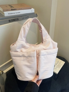 Chic pink quilted tote bag featuring two front pockets for stylish daily commute