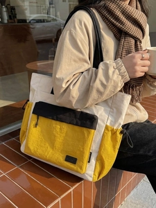 Stylish large capacity color-block tote bag for travel and fitness in outdoor cafe setting