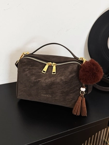 Sac à main vintage marron foncé en cuir texturé avec détails dorés et pompon en peluche