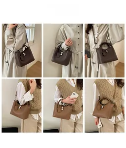 Close-up detail of leather bucket bags showing silver metal turn-lock and pebbled texture