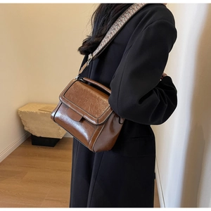 Detailansicht der braunen Vintage-Umhängetasche mit Kontrastnaht und breitem Gurt