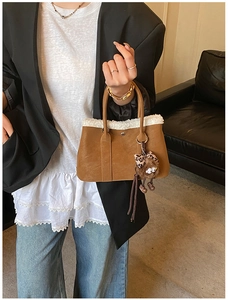 Brown leather bucket bag with white fleece trim and cute plush bear accessory
