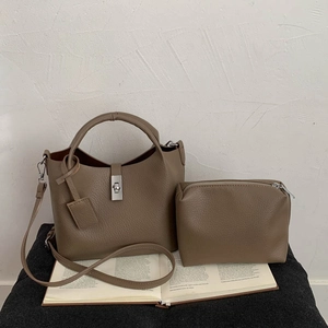 Taupe bucket bag set with matching pouch on open book background with shoulder strap