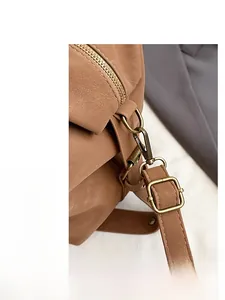 Detailed close-up of premium bronze hardware and textured leather on a caramel tote bag