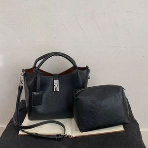 Detail of black lychee grain bucket bag set with silver twist lock and inner pouch