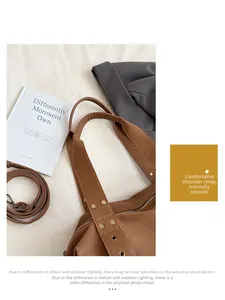 Detail view of brown leather tote bag with gold studs and adjustable wide shoulder strap