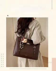 Detailed close-up of dark brown leather tote bag with vintage finish and side buckle