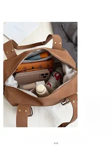 Top view showing spacious interior of brown tote bag with zipper and daily items