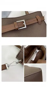 Détails du sac bandoulière en toile marron avec boucles argentées et sangles ajustables