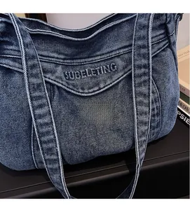 Detailed close-up of blue denim tote bag with vintage embroidery and twill texture