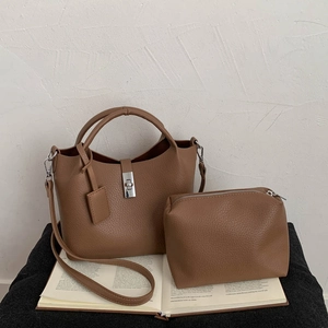 Detailed view of brown leather bucket bag with matching zipper pouch and silver hardware