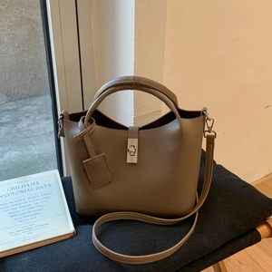 Close-up of coffee brown lychee pattern leather bucket bag with metal turn-lock closure
