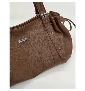 Detail of brown litchi pattern leather tote bag with silver hardware and drawstring