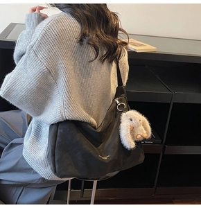 Bolso tote negro de estilo suave con colgante de conejo y suéter de punto gris