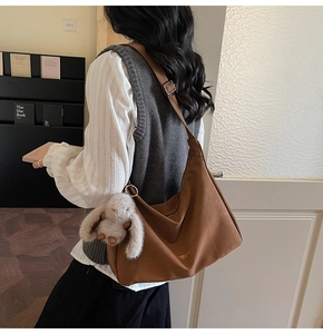 Bolso hobo marrón con correa ajustable y colgante de conejo visto desde atrás