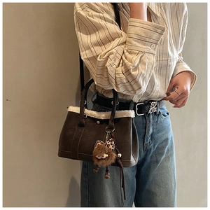 Brown retro bucket bag with white faux fur trim and plush leopard bow charm on model