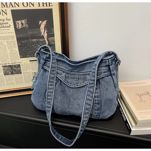 Gros plan du sac en denim bleu délavé avec broderie et texture plissée vintage