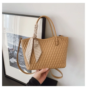 Detalle de bolso acolchado caqui con elegante decoración de pañuelo y correa de hombro