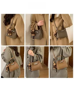 Litchi pattern leather bucket bag detail with teddy bear pendant and metal lock